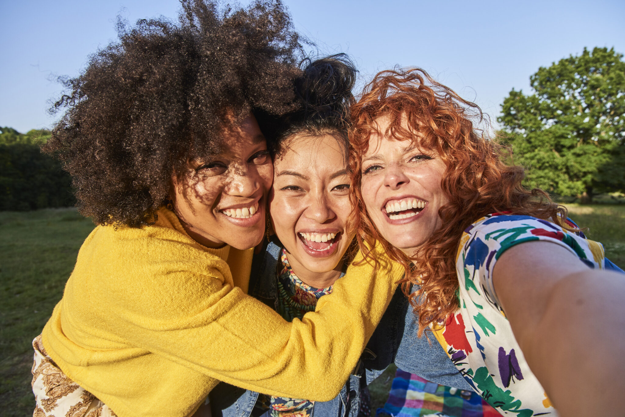 group of three women friends smiling