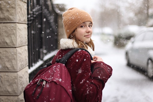 A girl going to the school in a snowy street