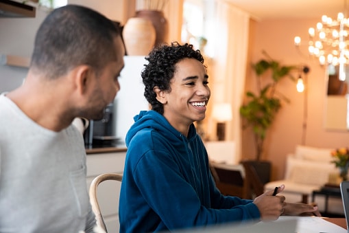 teenage son sitting at table with dad