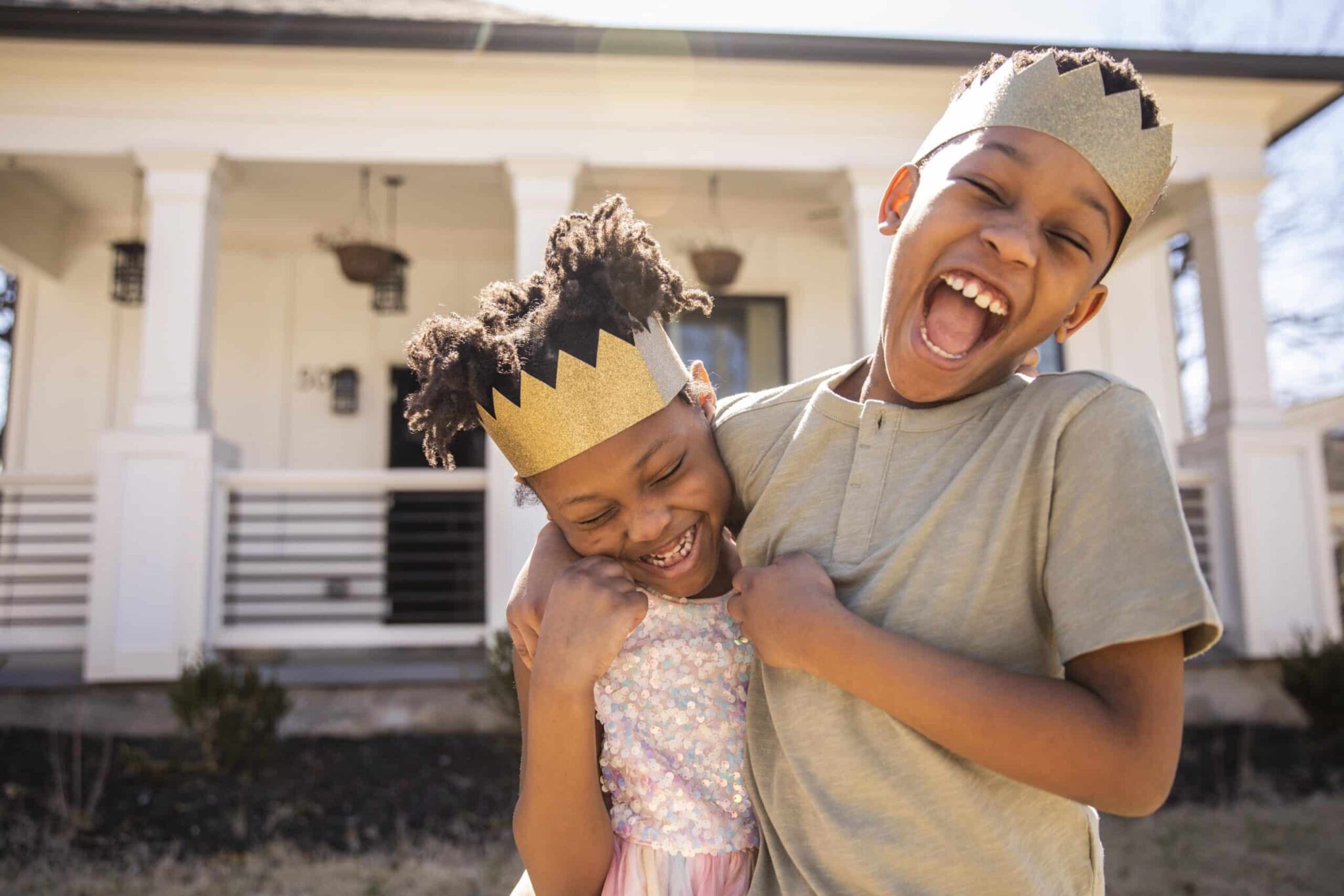brother and sister wearing crowns and laughing