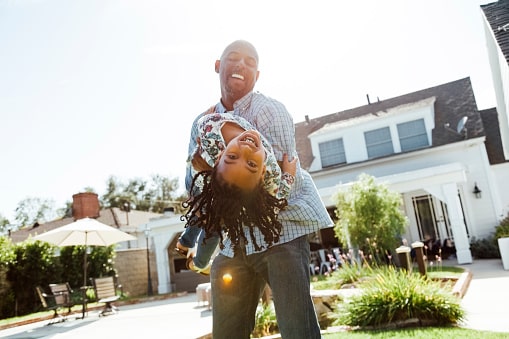 Father and daughter having fun in backyard at home