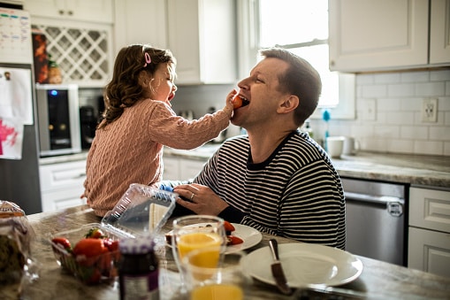toddler feeds her dad