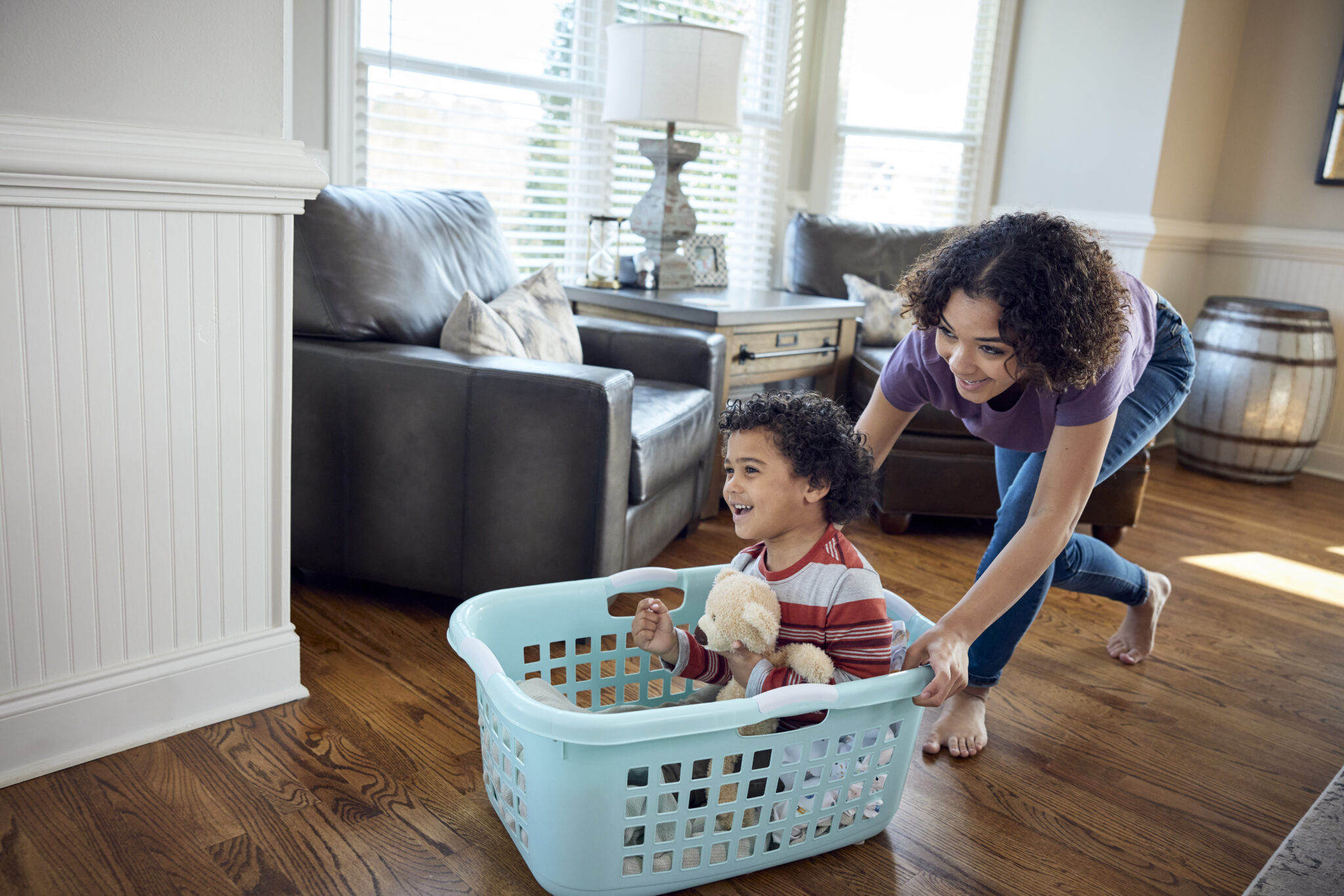 mom pushing her son in laundry basket