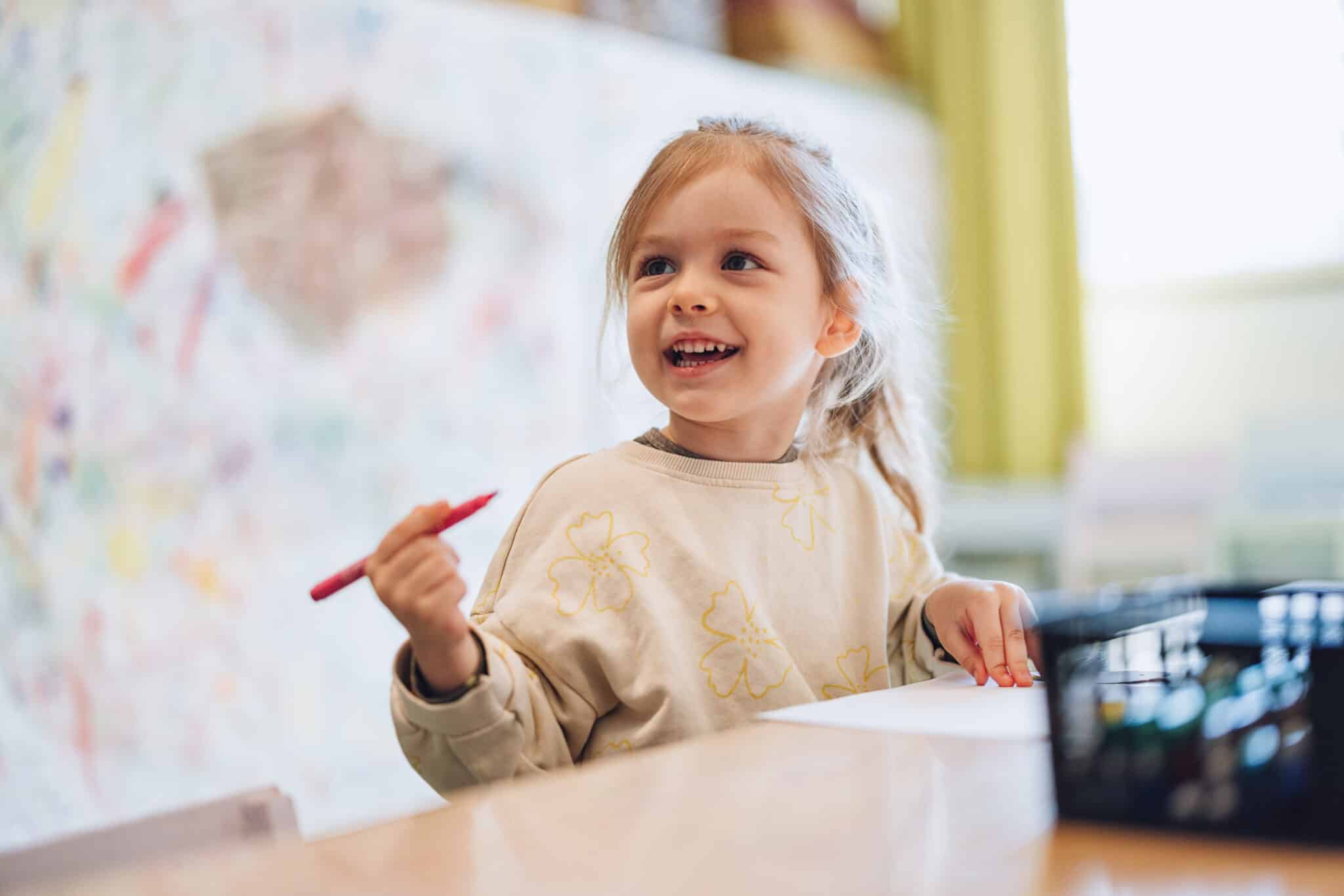 preschool girl coloring at school