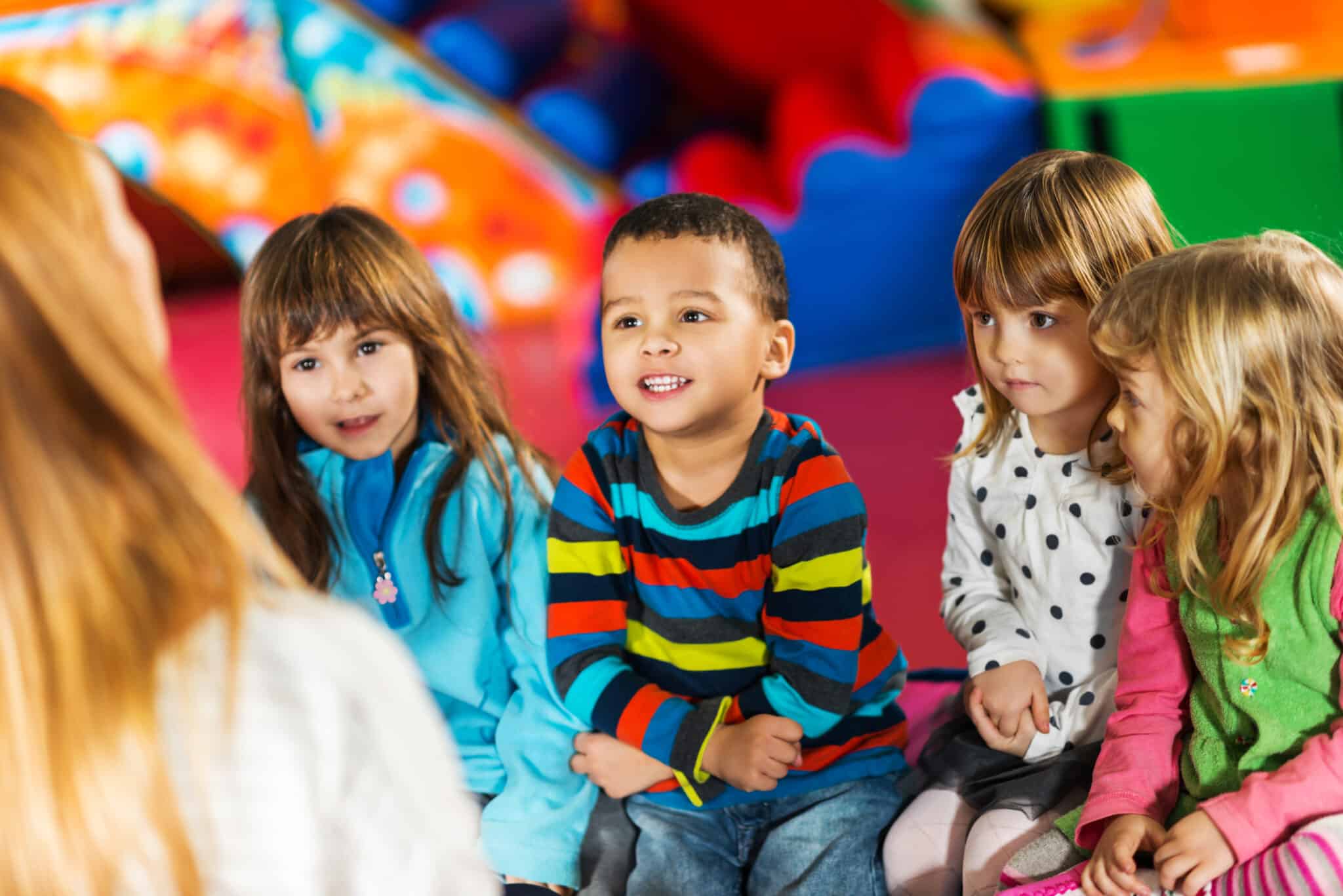 Cute kids listening to the nursery teacher