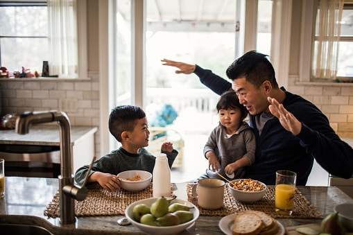 asian father having breakfast with his kids