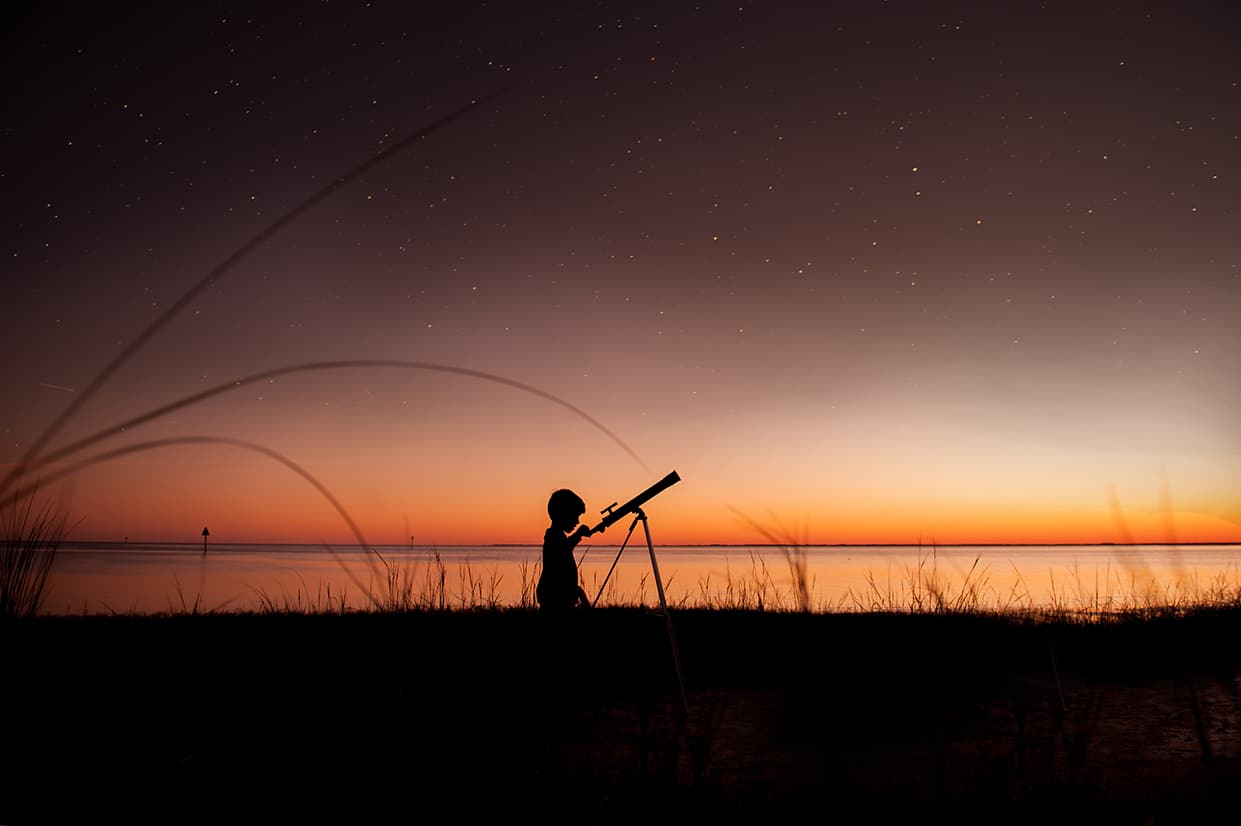 Child looking through telescope