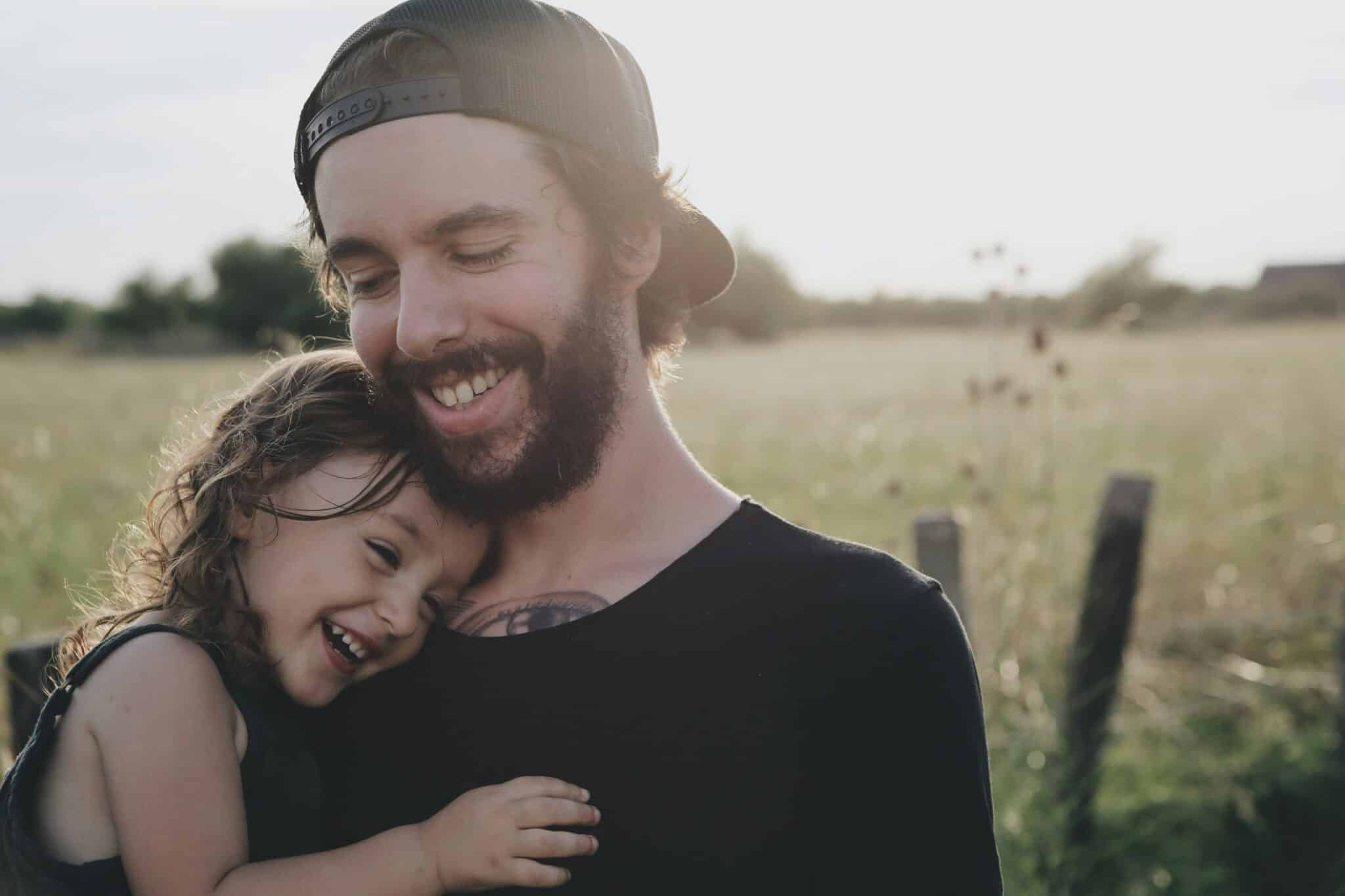 father holding daughter and smiling and laughing